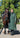 EQUIDRY women's long waterproof horse riding coat in black forest green/cream modelled by rider walking with horse