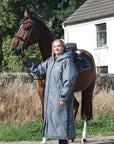EQUIDRY waterproof horse riding raincoat All Rounder Original thick fleece Women's Charcoal/Turquoise rider stood with horse full view