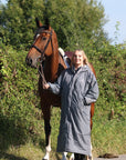 EQUIDRY women's long waterproof horse riding coat in charcoal/grey modelled by rider with horse