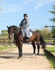 EQUIDRY women's long waterproof horse riding coat in charcoal/grey modelled by rider on horse