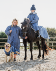 EQUIDRY women's long waterproof horse riding coat in steel blue/charcoal group family shot with horse and dog in matching rug and coat