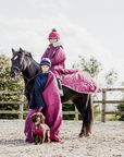 EQUIDRY Evolution Lux children's Warm Waterproof Winter Horse Riding Coat Thick Fleece Lining with Faux Fur Trim Hood being shown in plum with horse and dog