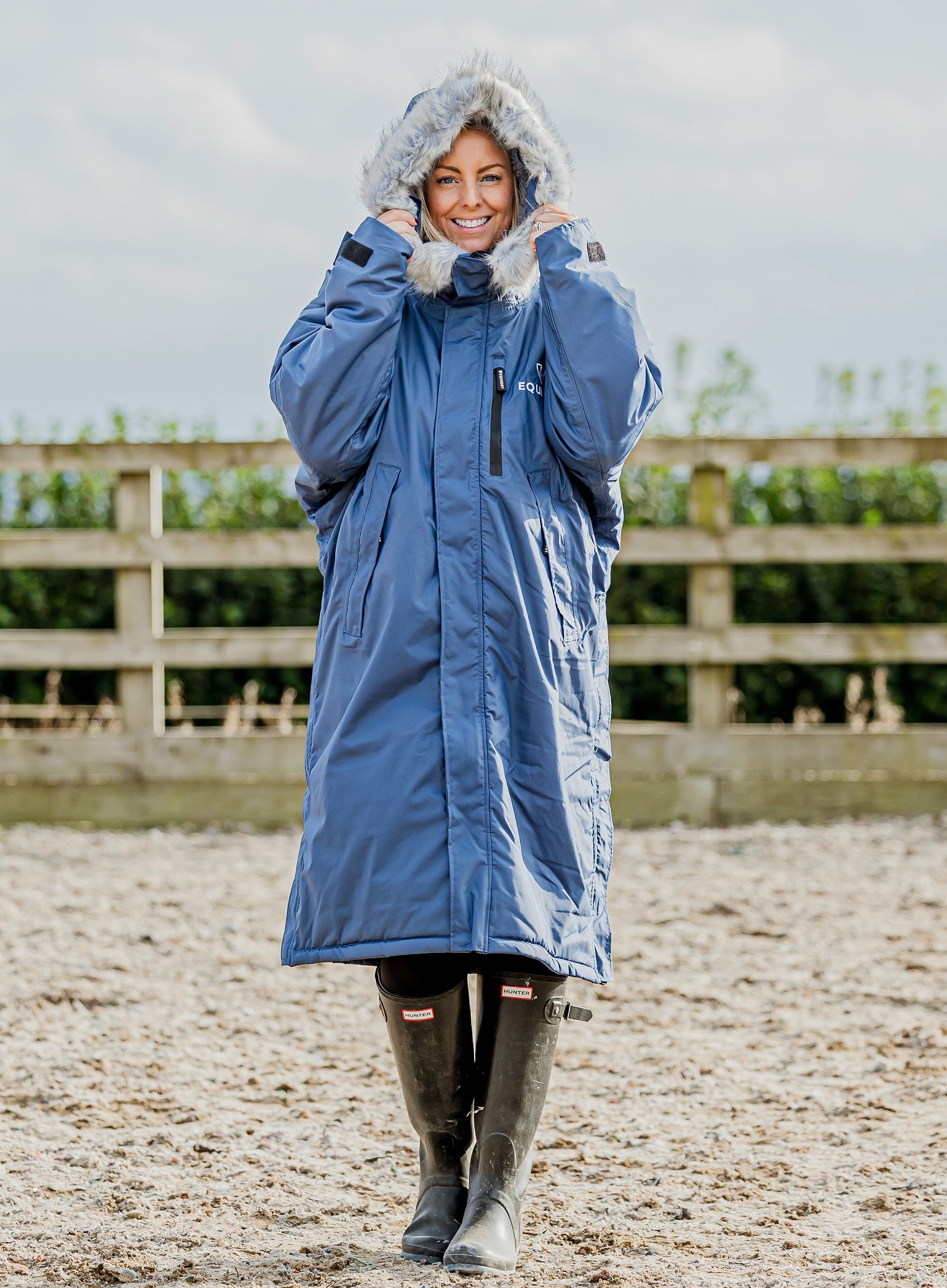 Evolution Lux Women's Warm Waterproof Winter Horse Riding Coat
Thick Fleece Lining with Faux Fur Trim Hood in steel blue rider in arena with hood up