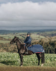 EQUIDRY women's waterproof short blouson style horse riding jacket in navy/raspberry on horse with blanket