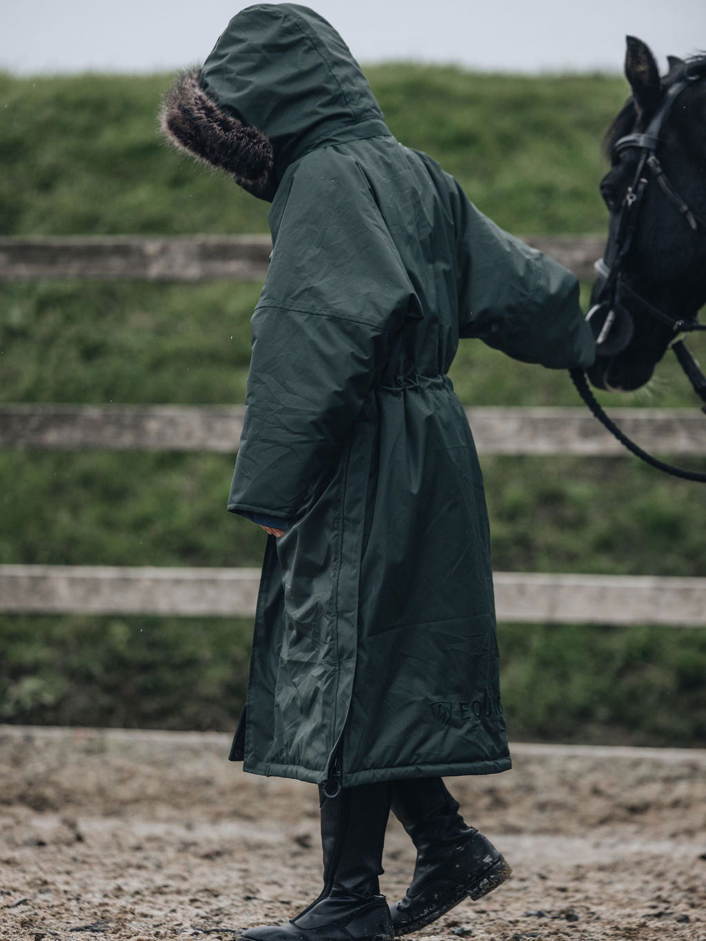 EQUIDRY |  Parka | Women&#39;s | Black Forest Green -  waterproof riding and leisure coat with padded inner detachable faux fur trim back view hood up rider in arena 