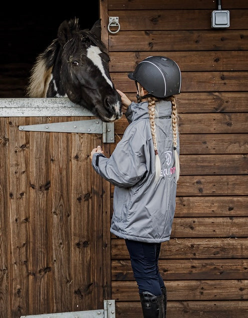 Shortie Child's Oversized Short Waterproof blouson style Riding Jacket Thin Fleece Lining Stowaway Hood in charcoal/penelope pink back view with horse 