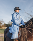 EQUIDRY women's thin fleece stowaway hood long waterproof horse riding coat in sky blue on horse 