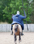 EQUIDRY men's long waterproof horse riding coat in navy/yellow worn by male stunt rider back of coat