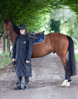  EQUIDRY men's long waterproof horse riding coat in Black/Yellow being modelled by male rider holding horse