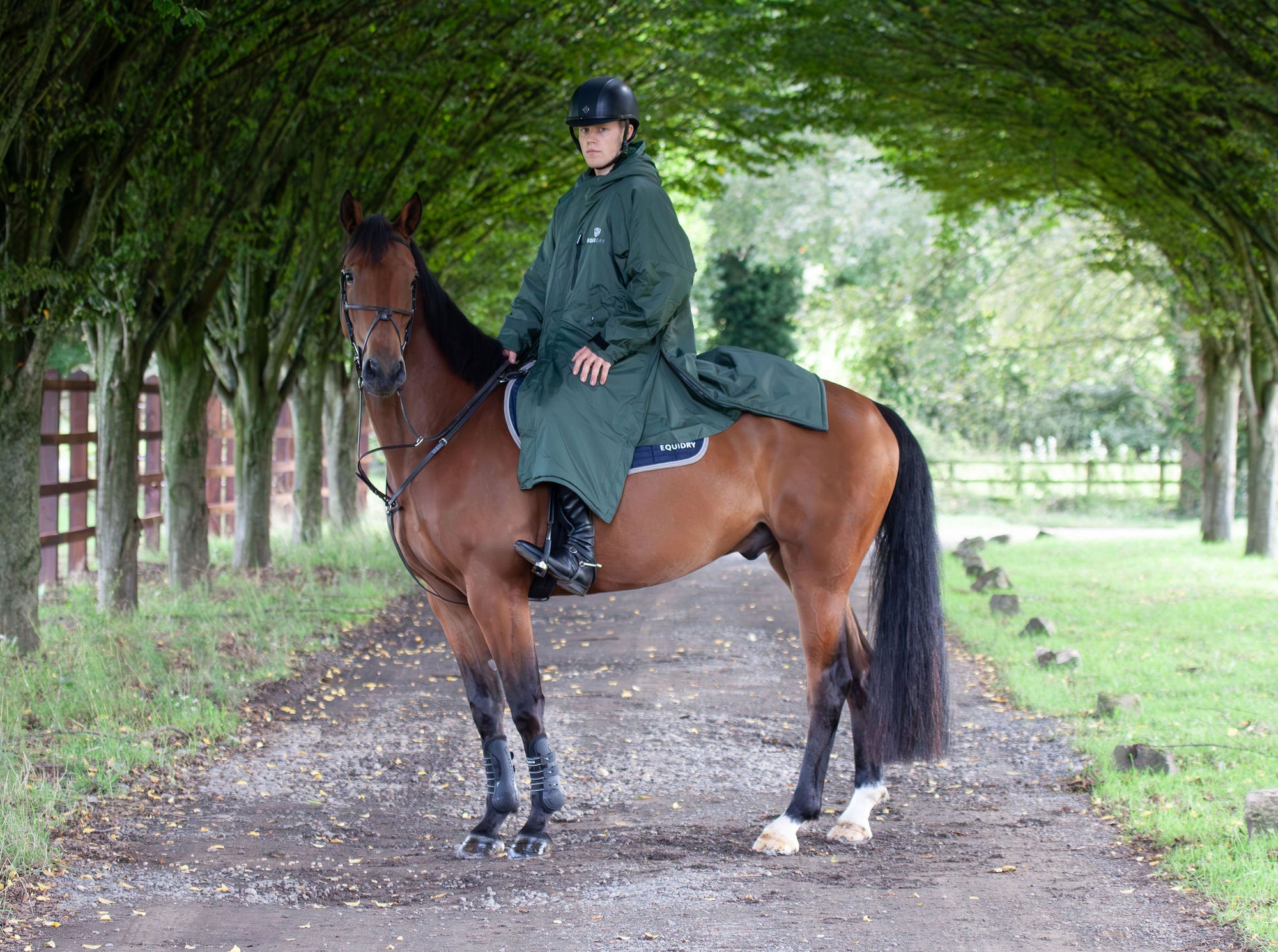 Black Forest Green EQUIDRY Equimac long waterproof raincoat worn by male rider on horse