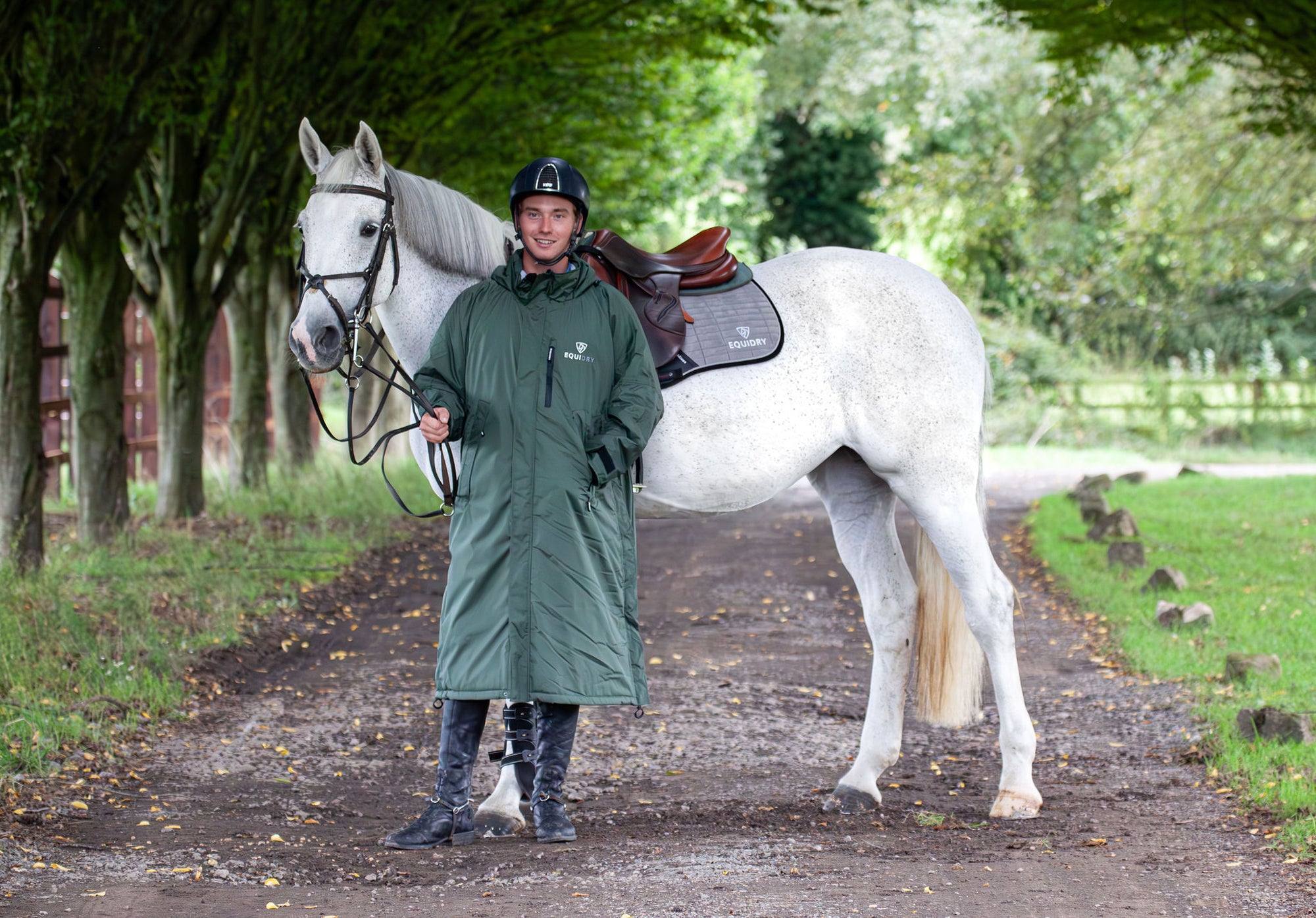 Evolution Pro men's Warm Waterproof Horse Riding Coat Thick Fleece Lining Stowaway Hood in Black Forest Green/Grey male rider stood with horse