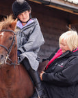 EQUIDRY women's long waterproof horse riding coat in black/peacock pink modelled by pony club instructor 