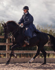 EQUIDRY Pro Ride Evolution  Equestrian oversized waterproof Horse Riding Coat in Navy modelled by rider training  for competition