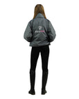 EQUIDRY women's waterproof short blouson style horse riding jacket in charcoal/penelope pink behind view studio 