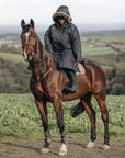 EQUIDRY Black Parka  with fur hood modelled by woman riding Horse cross country 