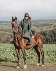 EQUIDRY Black Forest Green Parka  with fur hood modelled by woman riding Horse cross country 