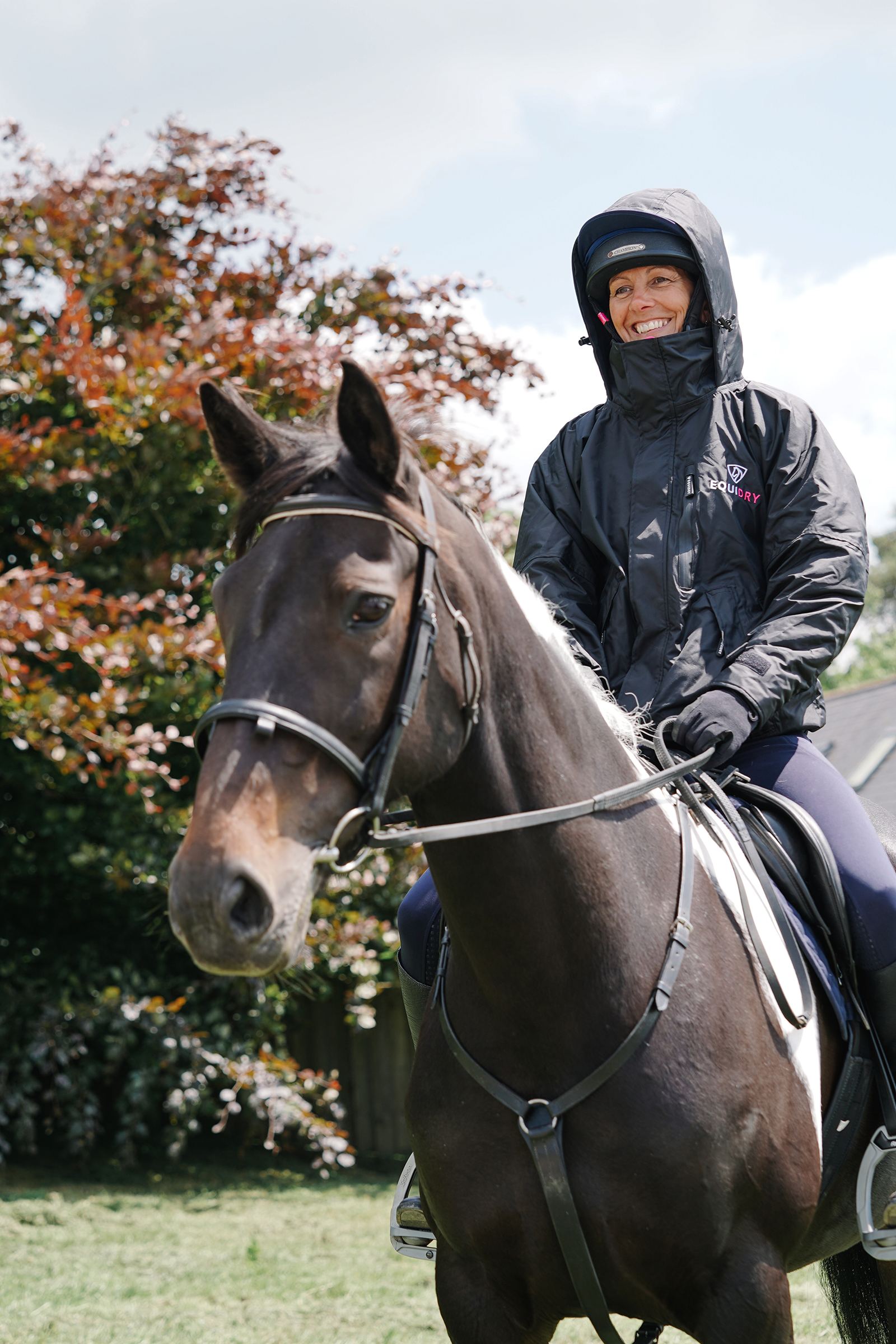 EQUIDRY women's waterproof short blouson style horse riding jacket in black/peacock pink being shown on horse