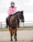 Shortie Child's Oversized Short Waterproof blouson style Riding Jacket Thin Fleece Lining Stowaway Hood in penelope pink shown by child on horse 